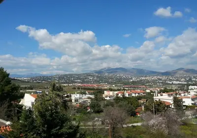 a view of a city with mountains in the background at Superb Athens Airport Residence, Unique View in Spáta