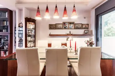 a dining room with a table with chairs and candles at Superb Athens Airport Residence, Unique View in Spáta