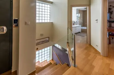 a staircase with a glass railing in a house at Superb Athens Airport Residence, Unique View in Spáta