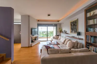 a living room with a couch and a tv at Superb Athens Airport Residence, Unique View in Spáta