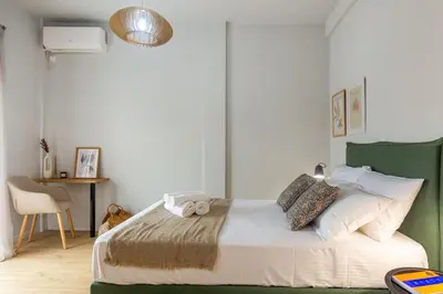 a bedroom with a bed with a green headboard at Cozy Studio near the Acropolis in Athens