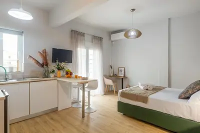 a bedroom with a bed and a desk and a kitchen at Cozy Studio near the Acropolis in Athens
