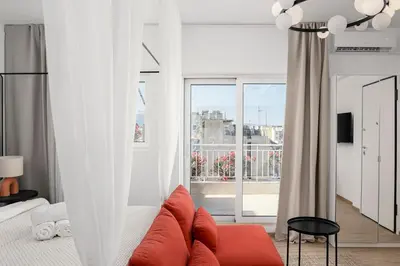a living room with a couch and a large window at Rooftops of Athens - Vathi Studio Jacuzzi & View in Athens