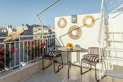 a balcony with a table and chairs and a view at Rooftops of Athens - Vathi Studio Jacuzzi & View in Athens