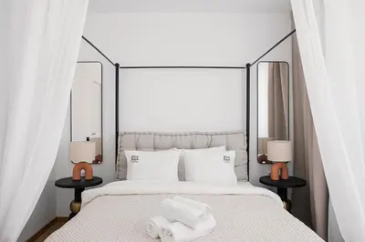 a bedroom with a white bed with towels on it at Rooftops of Athens - Vathi Studio Jacuzzi & View in Athens