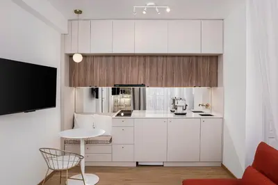a small kitchen with white cabinets and a table at Rooftops of Athens - Vathi Studio Jacuzzi & View in Athens