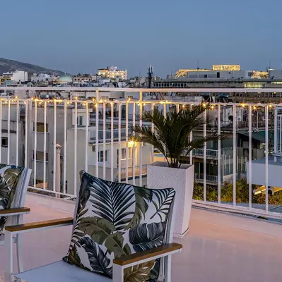 a balcony with chairs and a plant on a building at Rooftops of Athens - Vathi Studio Jacuzzi & View in Athens