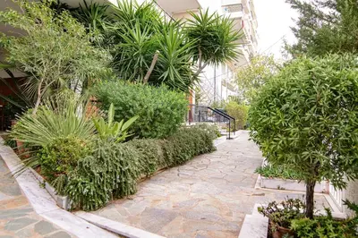 a garden with plants and a stone walkway at Elegant family apartment with marvelous garden in Athens