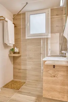 a bathroom with a shower with a sink and a window at Elegant family apartment with marvelous garden in Athens