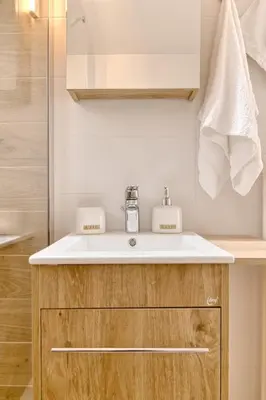 a bathroom with a white sink and a shower at Elegant family apartment with marvelous garden in Athens