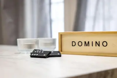 a pile of dominoes on a table next to a domino sign at Nova Domo in Athens