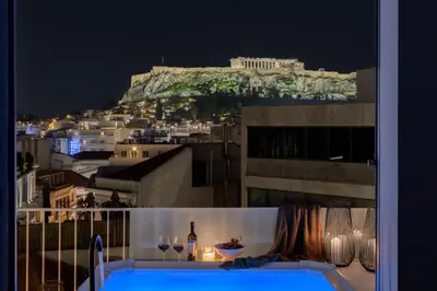a view of the acropolis from a balcony at night at Acropolis Penthouse Plunge Pool in Athens