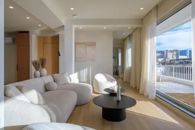 a living room with a couch and a large window at Acropolis Penthouse Plunge Pool in Athens