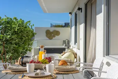 a table with food and drinks on a balcony at Acropolis Penthouse Plunge Pool in Athens