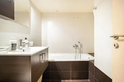 a bathroom with a bath tub and a sink at Easily accessible secure Ground floor with breakfast items in Athens