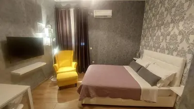 a bedroom with a bed and a yellow chair at Easily accessible secure Ground floor with breakfast items in Athens