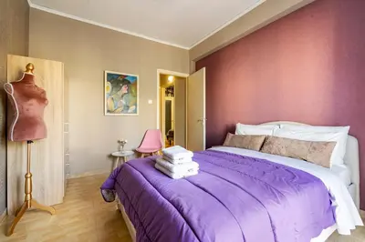 a bedroom with a purple bed and a pink wall at Sophisticated Penthouse and breakfast items in Athens