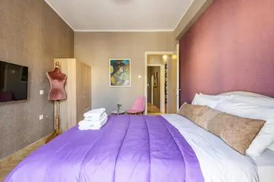 a bedroom with a large bed with a purple blanket at Sophisticated Penthouse and breakfast items in Athens