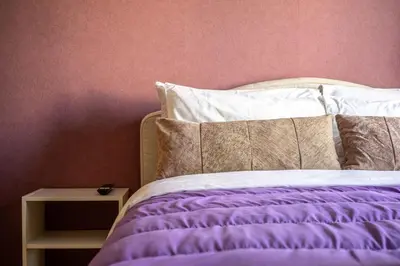 a bed with a purple comforter and a side table at Sophisticated Penthouse and breakfast items in Athens