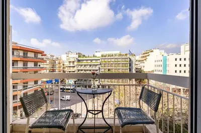 a balcony with a table and chairs and a city at Sophisticated Penthouse and breakfast items in Athens