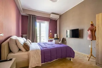 a bedroom with a purple bed and a window at Sophisticated Penthouse and breakfast items in Athens