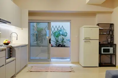 a kitchen with a refrigerator and a sliding glass door at Arditos Hill Residence in Athens