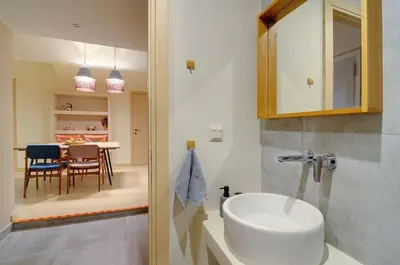 a bathroom with a sink and a dining room at Arditos Hill Residence in Athens