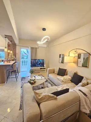 a living room with a couch and a table at Cozy Athens Stay near Metro Mall Casa Antigone in Athens