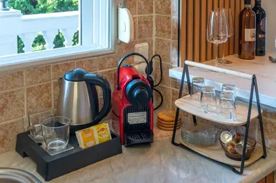 a kitchen counter with a mixer and glasses on it at Cozy Athens Stay near Metro Mall Casa Antigone in Athens