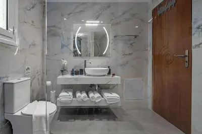 a bathroom with a sink and a toilet and a mirror at Cozy Athens Stay near Metro Mall Casa Antigone in Athens