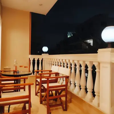 a dining room with a table and chairs and a balcony at Cozy Athens Stay near Metro Mall Casa Antigone in Athens