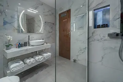 a bathroom with a shower and a sink and a mirror at Cozy Athens Stay near Metro Mall Casa Antigone in Athens
