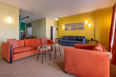 a living room with two orange couches and a table at Panoramic View Athenian Loft in Athens
