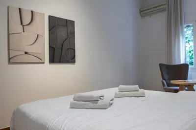 a bedroom with a white bed with towels on it at Lemon Garden Kolonaki Apartment in Athens