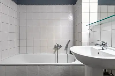 a white bathroom with a tub and a sink at Lemon Garden Kolonaki Apartment in Athens