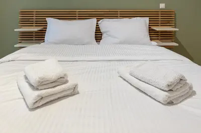 a white bed with towels on top of it at Lemon Garden Kolonaki Apartment in Athens