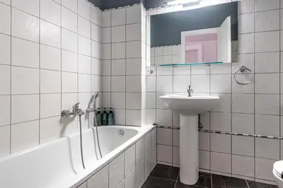 a white bathroom with a sink and a bath tub at Lemon Garden Kolonaki Apartment in Athens