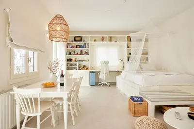 a white bedroom with a bed and a table and chairs at Camara Athens Riviera Home in Aghia Marina