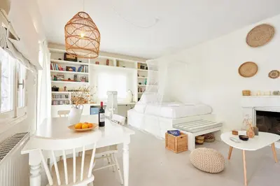 a white living room with a bed and a table at Camara Athens Riviera Home in Aghia Marina