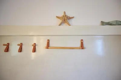 a shelf with four wooden crosses on a wall at Camara Athens Riviera Home in Aghia Marina