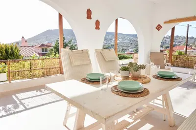 a wooden table and chairs on the balcony of a house at Camara Athens Riviera Home in Aghia Marina