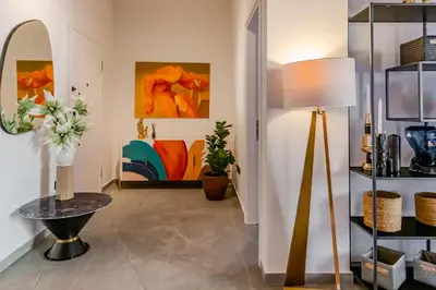 a living room with a lamp and paintings at Elysian Condo, Koukaki in Athens