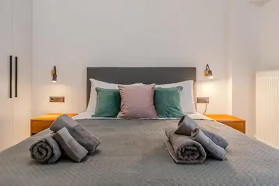 a large bed with pillows and towels on it at Elysian Condo, Koukaki in Athens