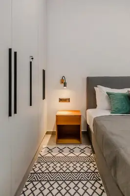 a bedroom with a bed and a nightstand next to a bed at Elysian Condo, Koukaki in Athens