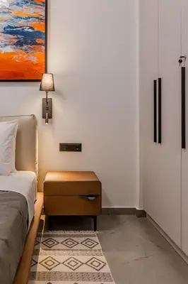 a bedroom with a bed and a table and a painting at Elysian Condo, Koukaki in Athens