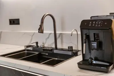 a kitchen counter with a sink and a coffee maker at Elysian Condo, Koukaki in Athens