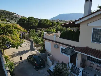 a car parked in a parking lot next to a house at Cozy House Oasis 15 min to airport & port, 35 min from Acropolis in Papangeláki
