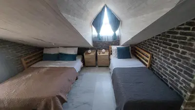 a room with two beds and a brick wall at Vacation Villa 5 bedrooms in Paianía