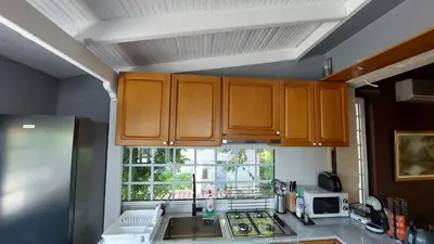 a kitchen with wooden cabinets and a window at Vacation Villa 5 bedrooms in Paianía