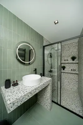 a bathroom with a sink and a shower and a mirror at Kalma Luxury Living Athens in Athens